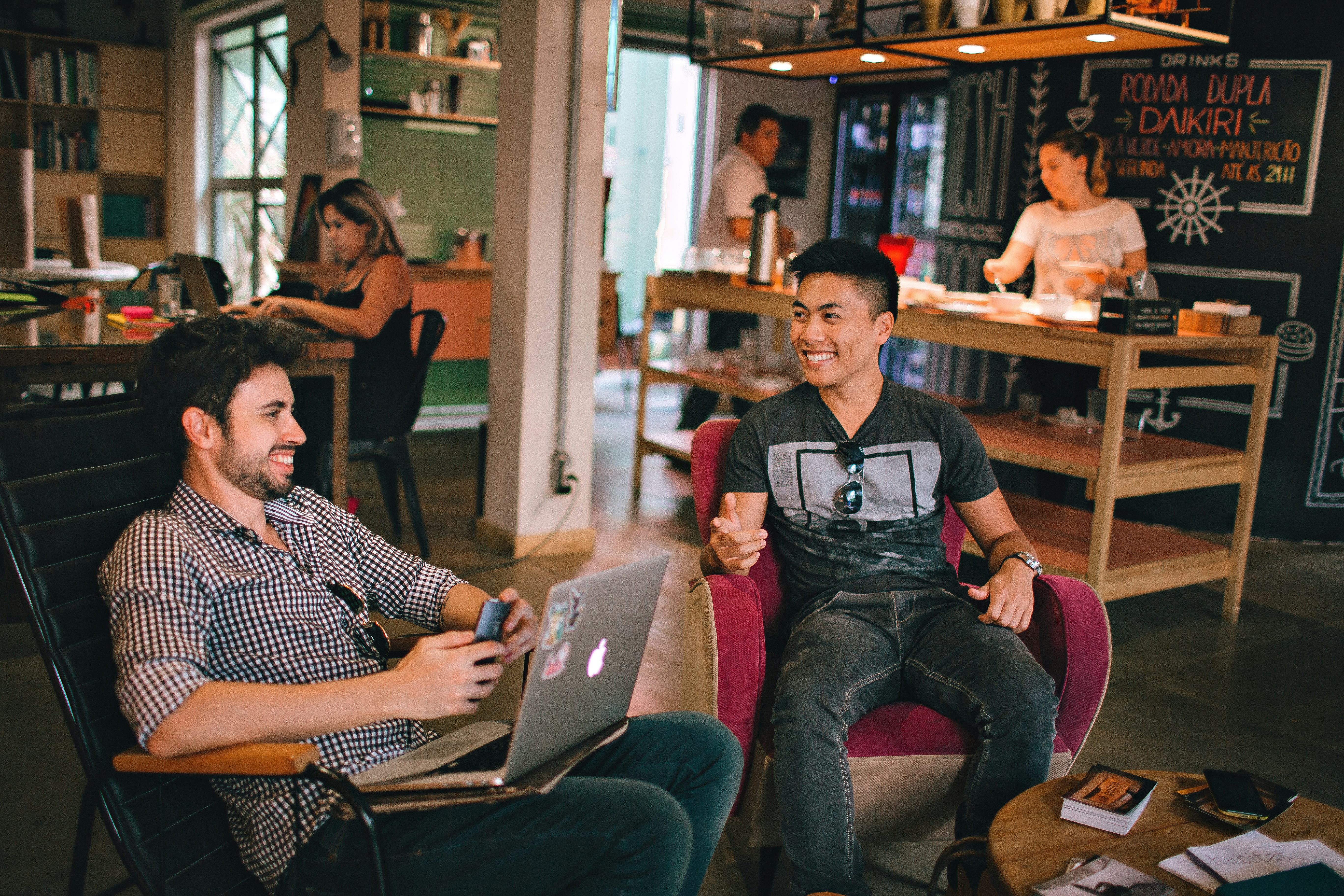 men sitting at a bar laughing 